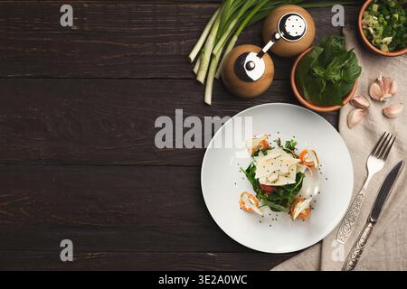 Gesunder Salat mit Garnelen und Gemüse auf einem rustikalen Holztisch zubereitet Stockfoto