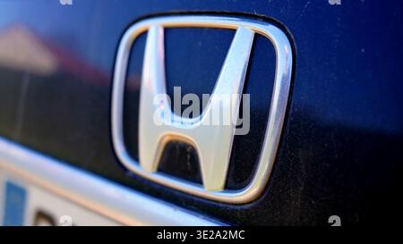 LYON, FRANKREICH - 19. MÄRZ 2026: Nahaufnahme des silbernen Honda-Emblems auf einem dunkelblauen Auto Stockfoto