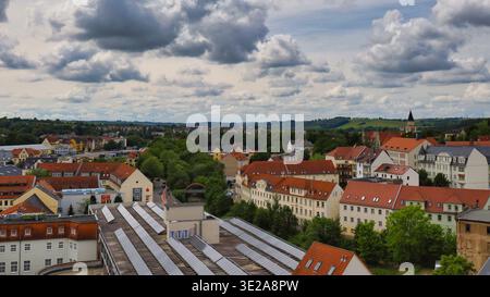 Stadtblick von Döbeln in Sachsen: Panorama vom Rathausturm über die Altstadt mit Wohnhäusern, grünen Alleen und Wolken Stockfoto