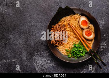 Eine Schüssel Ramen mit Nudeln, Fleisch und grünen Zwiebeln, Blick von oben. Stockfoto