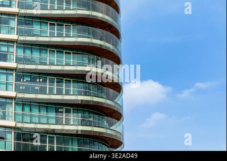 Mailand, Lombardei, Italien - Freitag, 13. 2026: Elegante, moderne Gebäudefassade, die sich vor blauem Himmel schwingt und das Licht reflektiert Stockfoto