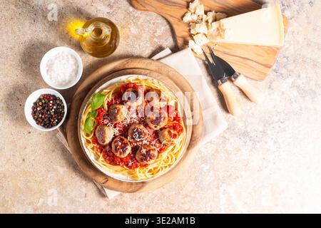 Ein Teller mit klassischen Spaghetti, garniert mit gebräunten Fleischbällchen und reichhaltiger Tomatensauce auf einem leichten Keramikgericht. Stockfoto