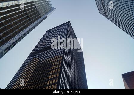 Blick auf drei moderne Wolkenkratzer in der Innenstadt von Toronto vor einem klaren, winterblauen Himmel mit geometrischen Linien, Reflexionen und Perspektive. Stockfoto