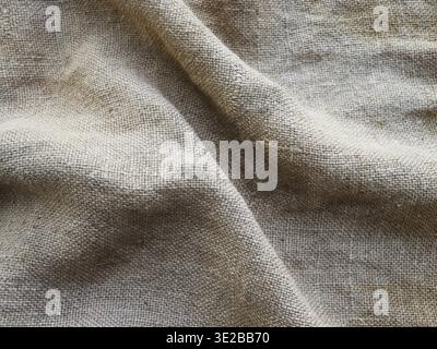 Die ländliche Beschaffenheit des Sacktuchs. Hintergrund aus sehr groben, groben Geweben aus Flachs, Jute oder Hanf. Leinenbeutelmaterial. Konstruktionselement. Abfeuern und Stockfoto
