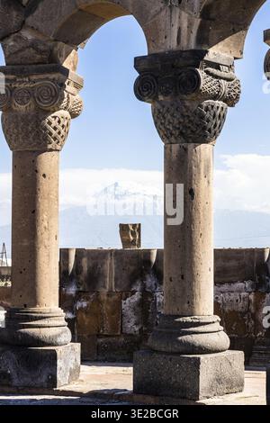 Säulen in der Kathedrale von Zvartnots und dem Berg Ararat auf dem Hintergrund in Armenien an sonnigen Sommertagen. Die Ruinen von Zvartnots sind zum UNESCO-Weltkulturerbe erklärt Stockfoto