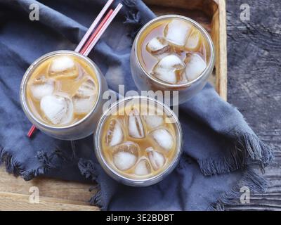 Kalt gebrühter Eiskaffee in hohem Glas auf hölzernem Hintergrund. Schokolade, Vanille, Karamell oder Zimt Eiskaffee in hohem Glas Stockfoto