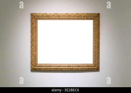 Alte geschnitzte breite hölzerne Bilderrahmen mit ausgeschnittener Leinwand an grauer Wand Stockfoto