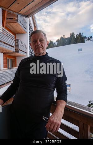 Person auf Balkon in Almhütte Oberlech, Lech, Österreich Stockfoto