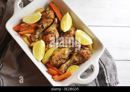Gegrillte Hähnchenschenkel mit saisonalem Gemüse in einer Grillpfanne auf dem Tisch Stockfoto