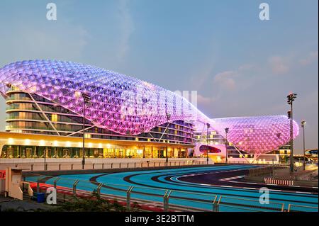 Das W Abu Dhabi Hotel hebt sich auf Yas Island mit hellen Lichtern ab, wenn sich die Nacht nähert. Besucher genießen das moderne Design und die Umgebung. Stockfoto