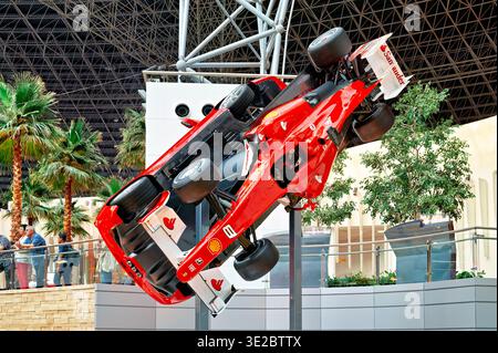 Besucher sehen eine Ferrari-Ausstellung auf der Ferrari World in Abu Dhabi. Das Fahrzeug wird verkehrt herum im Park gezeigt. Stockfoto