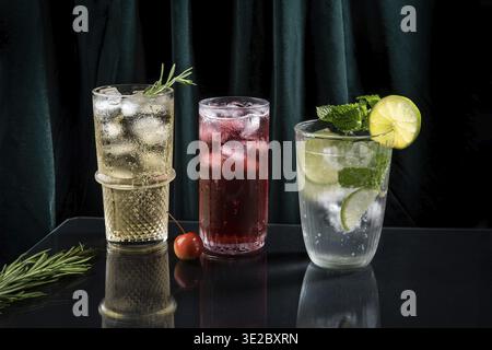 Drei lebendige und prickelnde alkoholische Punsch sind perfekt für die Weihnachtsfeier. Bunte Cocktails in Gläsern. Frische Feiertagsgetränke Stockfoto