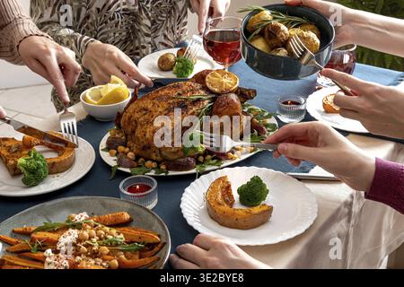 Leute, die Thanksgiving feiern. Tischdecken für Thanksgiving-Partys. Traditionelles weihnachtliches gefülltes Hühnchen-Abendessen mit Gemüse. Familienfeier oder Stockfoto