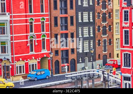 Ein lebendiges, detailreiches LEGO-Diorama, das eine bezaubernde europäische Grachtenstraße darstellt, die an die Amsterdamer Architektur erinnert. Die Szene ist farbenfroh. Stockfoto