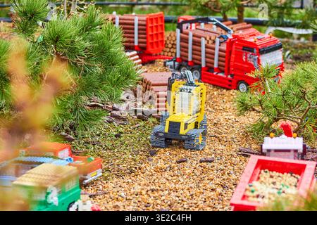Ein detailliertes Miniatur-Diorama für den Außenbereich mit Fahrzeugen für die Spielzeugbauweise und Holzfällern aus bunten Kunststoffbausteinen. Im Fenster... Stockfoto