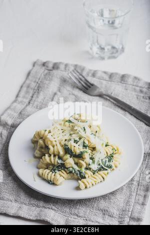 Food, Creamy Spinach Pasta with Ricotta and Parmesan on White Plate Stockfoto