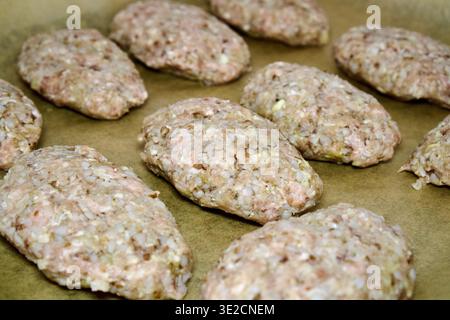 Rohe Fleischpasteten auf Backpapier vor dem Kochen Stockfoto