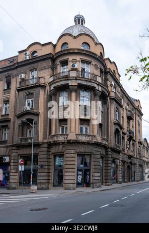 Historisches mehrstöckiges Eckgebäude mit kunstvoller Fassade, gewölbten Dachbalkonen und Bogenfenstern in einer ruhigen Straße. Architektonische Stadtlandschaft ohne Peo Stockfoto
