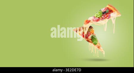 Leckere Pizzascheiben mit dehnbaren Käsesaiten in der Luft auf pastellgrünem Hintergrund. Bannerdesign mit Platz für Text Stockfoto