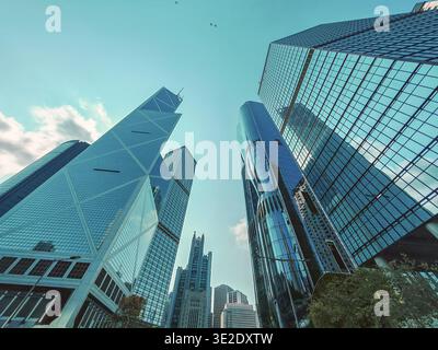 Ein beeindruckendes, flaches Foto, das die dynamische Skyline des modernen Hongkongs mit eleganten Wolkenkratzern und einer lebhaften Geschäftsatmosphäre zeigt. Stockfoto