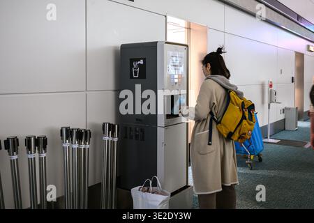 Frau, die eine Wasserflasche aus einem Wasserautomat auffüllt – Tokio, Japan – 13. November 2025 Stockfoto