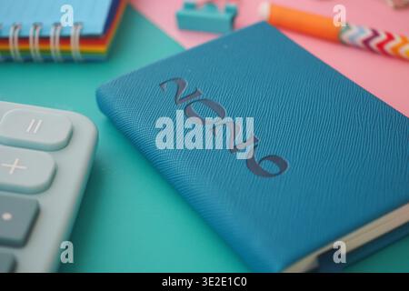 Notizbuch und Schreibwaren auf einem farbenfrohen Schreibtisch zum Studieren Stockfoto