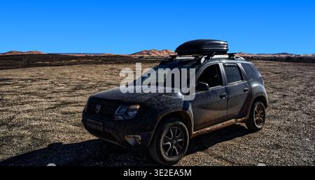 Dacia Duster Dirty suv mit Dachbox fährt auf einer zerklüfteten Wüstenpiste mit Sanddünen im Hintergrund in Merzouga, marokko, 8. januar 2026 Stockfoto