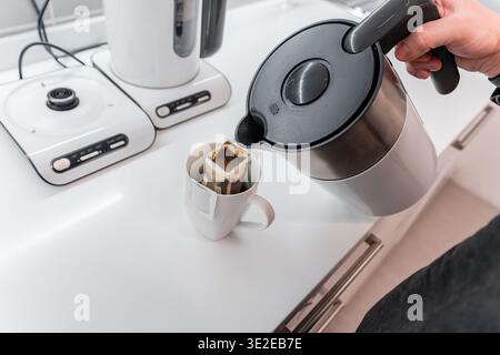 Die Person macht Kaffee aus Beutelfiltern Stockfoto