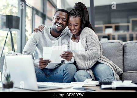 Aufgeregt, Dokumente und schwarzes Paar auf dem Sofa für Finanzen, Budgetplanung und Kreditgenehmigung für Hypotheken. Ehe, Heim und Mann mit Frau Stockfoto