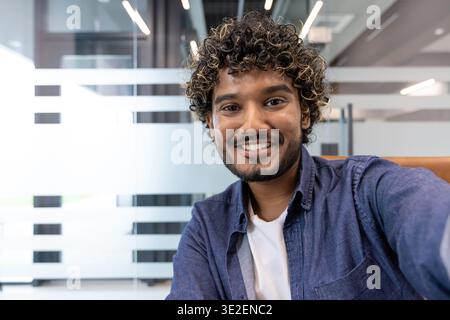 Nahaufnahme eines jungen Indianers in einem Büro, der redet und in die Kamera schaut. Stockfoto