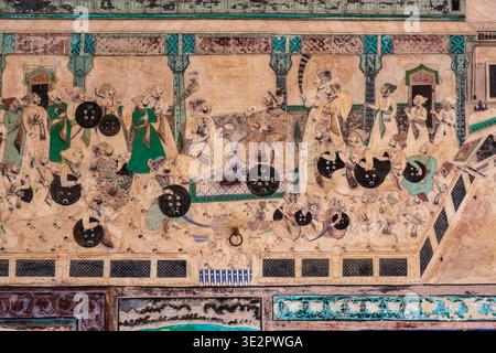 Ein komplexes Wandgemälde im Chitrashala von Bundi zeigt eine königliche Versammlung mit zahlreichen Figuren, die Schilde in einem Palaststil halten. Bundi Rajasth Stockfoto