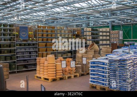 Wunderschöner Blick auf Gartentöpfe und Bodensäcke zum Verkauf, die in Regalen im Gartengeschäft angeordnet sind. Schweden. Stockfoto
