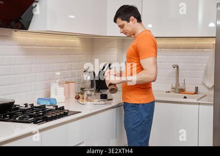 Mann schneidet Würstchen zum Frühstück Toast in heller Küche Stockfoto