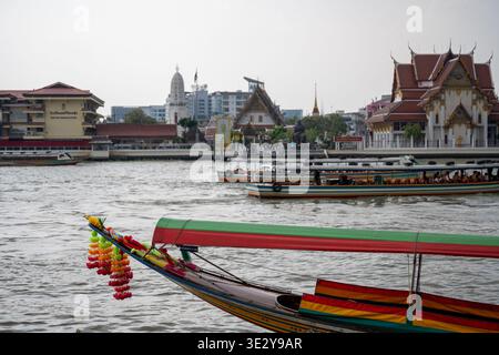 Bangkok Thailand 17. Januar 2026. Traditioneller langer Bootsbogen mit farbenfrohen Girlanden, die auf dem Fluss Chao Phraya in der Nähe des Wat Rakhang templ schwimmen Stockfoto