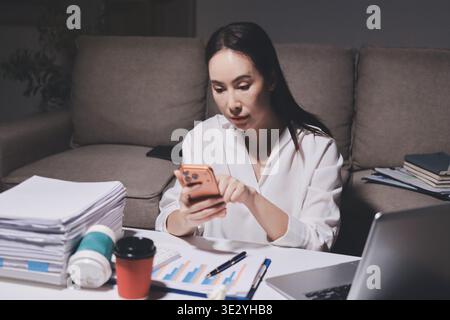 Erschöpfte weibliche Angestellte, die während der Überstunden Burnout erlitten hat. Eine müde Profi-Frau unter Druck mit Kopfschmerzen. Stockfoto