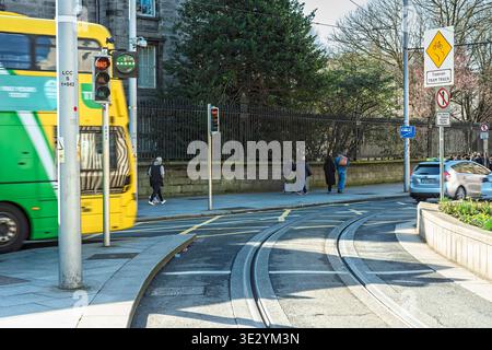 Luas-Tramgleise und ein vorbeifahrender Dublin-Bus an der Kreuzung der Hawkins Street in der Nähe des Trinity College. Stockfoto