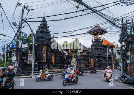 Verkehr und Motorräder vor Pura Desa Adat Seminyak Stockfoto