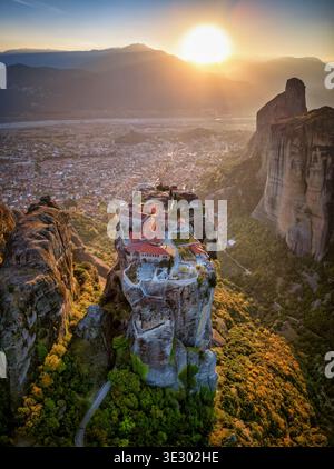 Blick auf den Sonnenuntergang von Meteora mit dem Kloster AGI Triada auf einer Klippe hoch über dem Tal Stockfoto