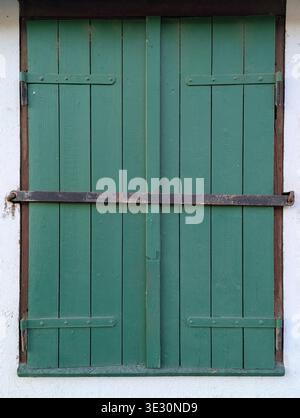 Grüne Doppeltüren Aus Holz Mit Verriegelung, Verwitterte Farbe, Vertikale Dielen, Rostscharniere, Weißer Putzrahmen, Weicher Schatten, Barn Caretaker Verriegelnder Entran Stockfoto