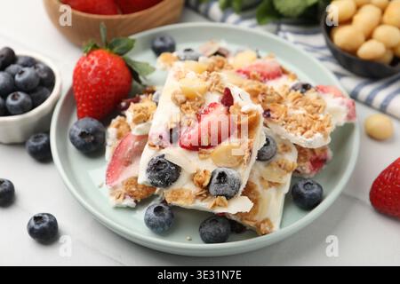 Leckere Joghurtrinde mit Beeren und Müsli auf dem Lichttisch, Nahaufnahme Stockfoto