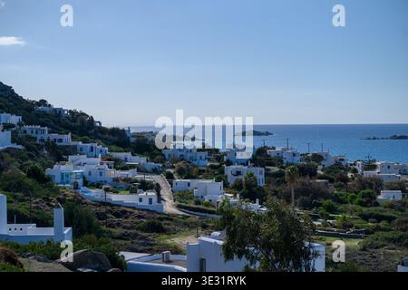 Weiß getünchte kykladische Gebäude mit Blick auf die Ägäis im griechischen Inseldorf mit blauen Fensterläden und traditioneller Architektur Stockfoto
