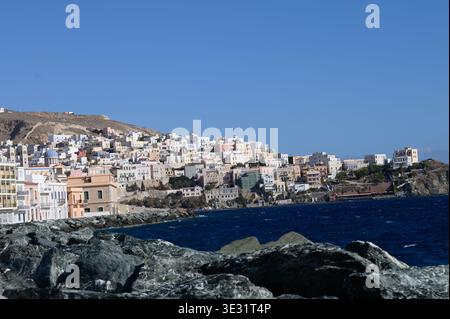 Farbenfrohe Hanggebäude mit Blick auf die tiefblaue Ägäis in Hydra, Griechenland Stockfoto