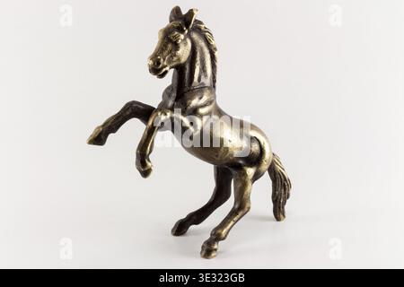 Eine akribisch gefertigte Bronzestatue eines aufziehenden Pferdes, erfasst mit sauberer Studiobeleuchtung auf reinweißem Hintergrund, ideal für verschiedene Designprojekte Stockfoto