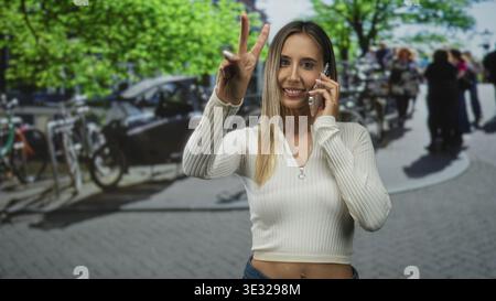 Frau, die mit dem Smartphone spricht und mit dem Finger auf eine geschäftige Straße zeigt, neben geparkten Fahrrädern und Fußgängern; Vertrauen in die Verbindung in die Stadt. Stockfoto