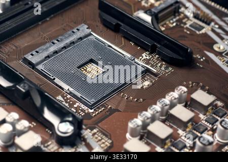 Leerer schwarzer cpu-Sockel auf brauner Leiterplatte, elektronische Kondensatoren, Nahansicht mit Weichfokus, Reparatur von Computerhardware Stockfoto