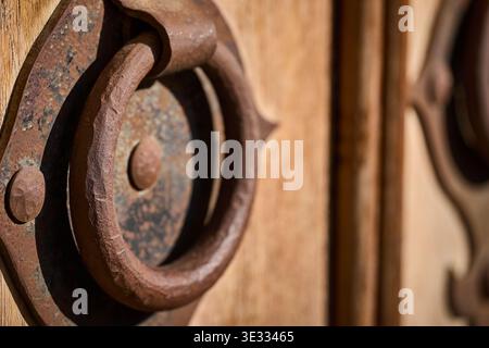 Makroaufnahme eines verwitterten Metallklopfers auf traditioneller Holzoberfläche, rustikale Textur Stockfoto
