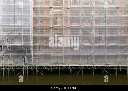 Gerüstbau auf einer Baustelle in der Hamburger Speicherstadt im Kanalwasser. Nahaufnahme des Sicherheitsnetzes. Stockfoto