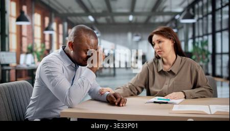 Junger Afroamerikanischer Geschäftsmann, Der Sich Während Der Geschäftigen Büroarbeit Gestresst Und Aufgebracht Fühlt Stockfoto