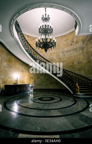Elegante geschwungene Treppe mit Kronleuchtern und Marmorboden im Ministério da Fazenda-Gebäude in Rio de Janeiro, Brasilien Stockfoto
