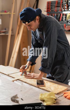 Zimmermann vermessen Holzdielen mit Maßbandarbeiten in der Holzwerkstatt Markierungen. Kopierbereich Stockfoto